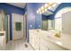 Well-lit bathroom featuring dual sinks, vaulted ceiling, and large mirror at 2430 Harbin Springs Cv, Dacula, GA 30019