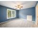 Cozy bedroom with natural light, ceiling fan, and neutral carpet at 2430 Harbin Springs Cv, Dacula, GA 30019