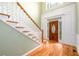 Grand foyer with hardwood floors, staircase, and elegant front door with side windows at 2430 Harbin Springs Cv, Dacula, GA 30019