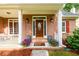 Welcoming front porch with brick facade, decorative plants, and stylish front door at 2430 Harbin Springs Cv, Dacula, GA 30019