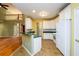 Bright kitchen with white cabinetry, breakfast bar, and open floor plan to the living area at 2430 Harbin Springs Cv, Dacula, GA 30019