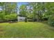 This backyard has a large lawn and deck area, surrounded by mature trees, offering privacy at 3539 Eaglerock Dr, Doraville, GA 30340