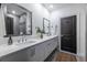 Modern bathroom featuring double sinks, a large mirror, and a dark-colored door at 399 Pratt Se Dr # 910, Atlanta, GA 30315