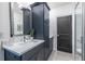 Contemporary bathroom featuring dark blue cabinetry, double sinks, a sleek mirror, and modern fixtures for an upscale feel at 399 Pratt Se Dr # 910, Atlanta, GA 30315