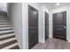 Hallway with hardwood floors, three dark doors and a staircase leading to the next level at 399 Pratt Se Dr # 910, Atlanta, GA 30315