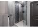 Modern shower featuring gray tile, decorative accent tile, a rainfall shower head, and glass door at 399 Pratt Se Dr # 910, Atlanta, GA 30315