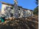 Exterior view of home's rear featuring beige siding, patio, and expansive lawn at 5622 Platte Dr, Ellenwood, GA 30294