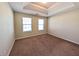 Bedroom with neutral walls, carpeted floor, two windows, and a tray ceiling at 5622 Platte Dr, Ellenwood, GA 30294
