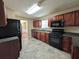 Kitchen features wood cabinets, dark appliances, and tile flooring for easy maintenance at 5622 Platte Dr, Ellenwood, GA 30294