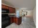 Open concept kitchen with black appliances, dark countertops, and view to living room at 5622 Platte Dr, Ellenwood, GA 30294