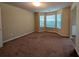 Bright living room featuring neutral walls, brown carpet, and large windows offering natural light at 5622 Platte Dr, Ellenwood, GA 30294