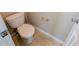 Neutral-toned powder room featuring a standard toilet, tiled floor and wall-mounted paper holder at 5622 Platte Dr, Ellenwood, GA 30294
