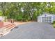 View of backyard with a detached garage and concrete driveway and a raised deck with stone steps at 1039 Ridgecrest Se Dr, Smyrna, GA 30080