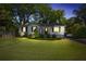 Charming exterior of home with white brick, dark shutters, front porch, and landscaped front yard at night at 1039 Ridgecrest Se Dr, Smyrna, GA 30080