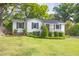 Charming exterior of home with white brick, dark shutters, front porch, and landscaped front yard at 1039 Ridgecrest Se Dr, Smyrna, GA 30080