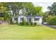 Charming exterior of home with white brick, dark shutters, front porch, and landscaped front yard at 1039 Ridgecrest Se Dr, Smyrna, GA 30080
