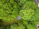 An aerial view showing the home is nestled among mature trees, providing shade and privacy at 104 River Creek Dr, Woodstock, GA 30188