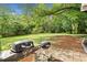 Spacious backyard featuring lush greenery, a patio with a grill, and ample space for outdoor activities at 104 River Creek Dr, Woodstock, GA 30188
