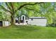 Exterior view of home with large backyard, mature trees, and screened-in porch at 104 River Creek Dr, Woodstock, GA 30188