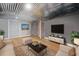 Staged basement with light wood floors, corrugated metal ceiling, and neutral colored furniture at 104 River Creek Dr, Woodstock, GA 30188