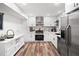 Modern kitchen with white cabinets, stainless steel appliances, and stylish backsplash at 104 River Creek Dr, Woodstock, GA 30188