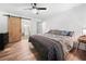 Spacious bedroom with barn door entrance to bathroom, ceiling fan, and hardwood floors at 104 River Creek Dr, Woodstock, GA 30188