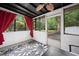 Relaxing sunroom with red curtains, ceiling fan, black and white floral patterned rug, and view to backyard at 104 River Creek Dr, Woodstock, GA 30188