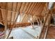 Unfinished attic space, featuring exposed beams and rafters, with a single window and flooring at 1045 Legacy Walk, Woodstock, GA 30189