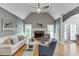 Bright living room with vaulted ceiling, hardwood floors, stone fireplace, and large windows overlooking the backyard at 1045 Legacy Walk, Woodstock, GA 30189