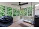Covered porch with white swing, ceiling fan, and wooded views at 1045 Legacy Walk, Woodstock, GA 30189