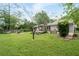 Lush backyard with expansive green space, a deck, patio seating, and a hammock, ideal for outdoor enjoyment at 515 Houze Way, Roswell, GA 30076