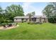 Expansive backyard featuring a fire pit with chairs, a wooden deck, and lush greenery, great for outdoor living at 515 Houze Way, Roswell, GA 30076