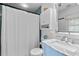 Bright bathroom featuring a shower with curtain, sink with blue vanity and marble countertop at 515 Houze Way, Roswell, GA 30076