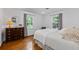 Bright bedroom with hardwood floors, dresser, and windows offering natural light and outdoor views at 515 Houze Way, Roswell, GA 30076