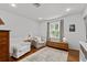 Comfortable bedroom with a large window, seating area, and hardwood floors at 515 Houze Way, Roswell, GA 30076
