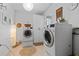 Modern laundry room with front loading machines, white cabinets, and ample lighting at 515 Houze Way, Roswell, GA 30076
