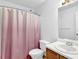 Bathroom featuring a shower with pink curtain, white toilet and sink with light fixture at 6359 Wedgeview Dr, Tucker, GA 30084