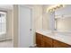 Bathroom with light wood cabinets, white sink, and a large mirror reflecting the bedroom at 6359 Wedgeview Dr, Tucker, GA 30084