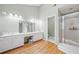 Bright bathroom featuring dual sinks, hardwood floors, a walk-in shower, and contemporary finishes at 1763 Benningfield Sw Dr, Marietta, GA 30064