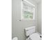 Small bathroom featuring a toilet, window, and hardwood floors, providing a basic and functional space at 1763 Benningfield Sw Dr, Marietta, GA 30064