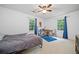 Well-lit bedroom featuring two windows, desk area, and ceiling fan at 1763 Benningfield Sw Dr, Marietta, GA 30064