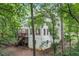 Two-story home exterior with a wooden deck and stairs surrounded by lush trees at 1763 Benningfield Sw Dr, Marietta, GA 30064