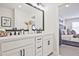 Stylish bathroom with dual sinks, white cabinets, modern fixtures, and access to bedroom at 1923 Deco Dr, Kennesaw, GA 30144