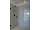 Modern shower with clear glass enclosure and gray tile, featuring black hardware at 1923 Deco Dr, Kennesaw, GA 30144