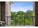Stone balcony with black metal railing overlooking lush green trees and distant buildings on a sunny day at 3280 Stillhouse Se Ln # 401, Atlanta, GA 30339