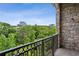 Balcony with stone walls, black iron railing, and a lush view of the tree tops at 3280 Stillhouse Se Ln # 401, Atlanta, GA 30339