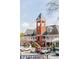 Multi-level building with brick tower, white columns, and balconies in Vinings Jubilee near retail shops at 3280 Stillhouse Se Ln # 401, Atlanta, GA 30339