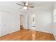 Bedroom with wood floors, white trim, ceiling fan, and a view into the bathroom at 3425 Poplar Dr, Lawrenceville, GA 30044