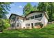 View of the rear exterior showing the house with a lawn, trees, and a white brick facade at 3425 Poplar Dr, Lawrenceville, GA 30044