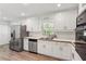 Bright kitchen featuring white cabinets, stainless steel appliances, and a window over the sink at 3425 Poplar Dr, Lawrenceville, GA 30044